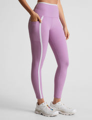 purple high-waisted midi length legging with pockets and white piping.