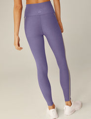 purple high-waisted midi leggings with gray trim down the side.