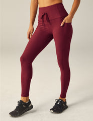 red waisted midi leggings with a drawstring at the waistband and side pockets.