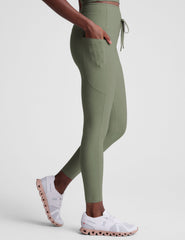 green high-waisted midi length leggings with pockets and a drawstring at waistband.