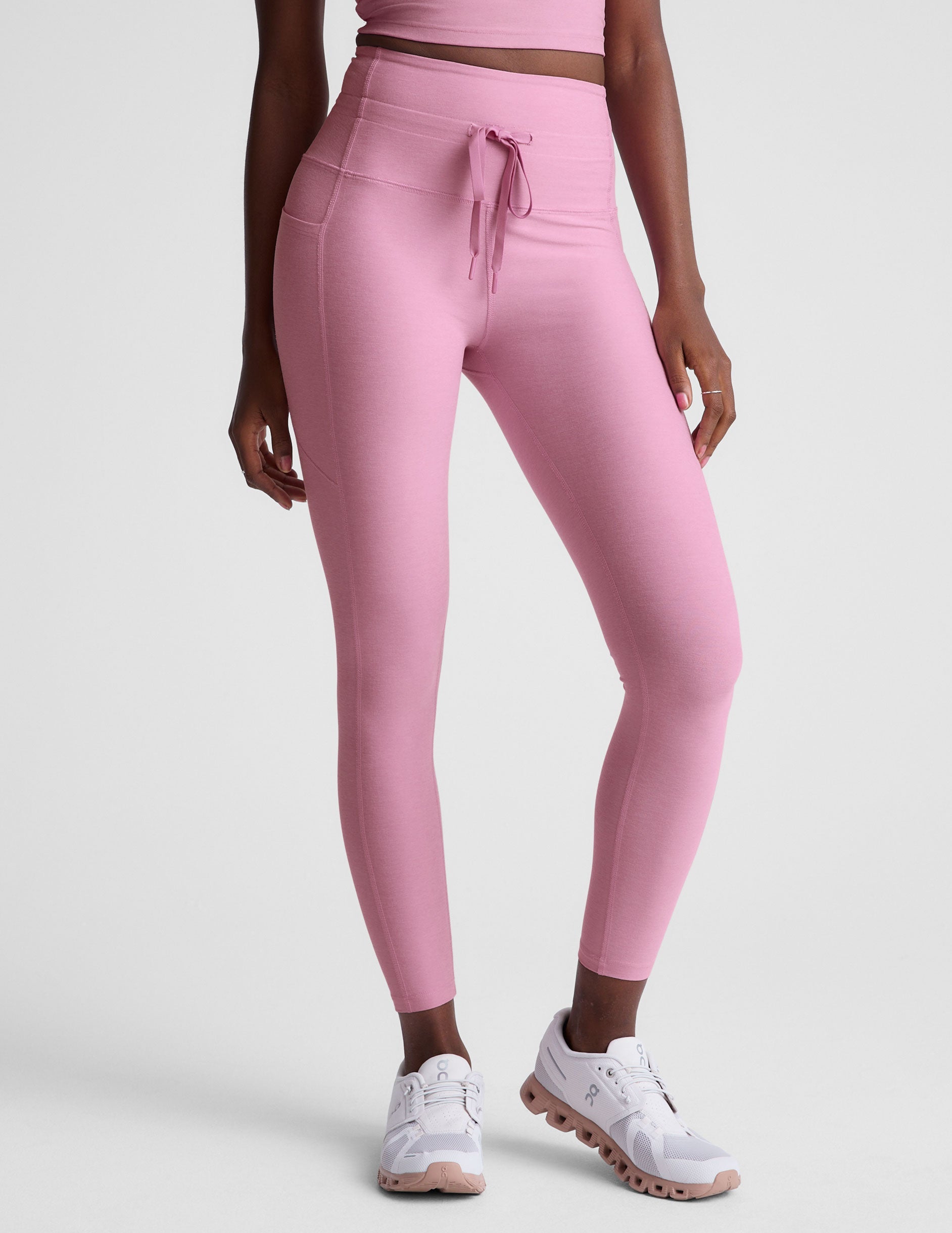 pink high-waisted midi length leggings with a drawstring at the waist and side pockets.
