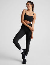 black high-waisted midi length legging with a shirred detail on the sides of the waistband.