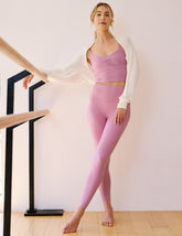 pink high-waisted midi length leggings with shirred detailing on the side of each waistband.