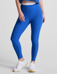 blue high-waisted midi leggings with white contrast piping on side of leg and around waistband.