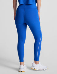 blue high-waisted midi leggings with white contrast piping on side of leg and around waistband.
