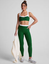 green high-waisted midi leggings with white contrast piping on side of leg and around waistband.