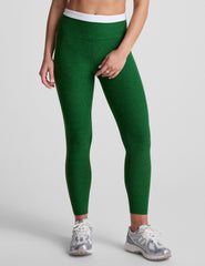 green high-waisted midi leggings with white contrast piping on side of leg and around waistband.