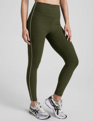 green high-waisted midi length leggings with white piping along sides.