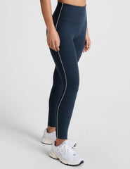blue high-waisted midi length leggings with white piping on the side.