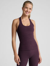 model wearing a purple racerback tank top and purple high-waisted midi length leggings.