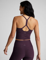 purple slim racerback cropped tank top and purple leggings on a plain background.