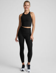 woman wearing a black high neck racerback cropped tank on a plain background.