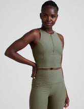 front image of a green racerback cropped tank with a half zip up detail in front.