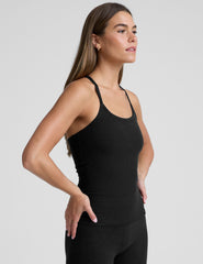 woman wearing a full length racerback tank top and leggings against a plain background.