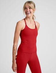 model wearing a red racerback full length tank top against a plain background.