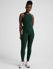 model is wearing a green high neck full length racerback tank top and leggings against a plain background.