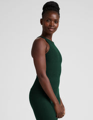 model is wearing a green high neck full length racerback tank top and leggings against a plain background.