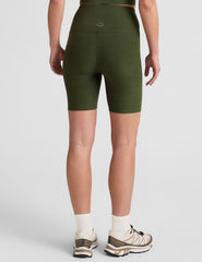 model is wearing green high-waisted 7" inseam biker shorts.