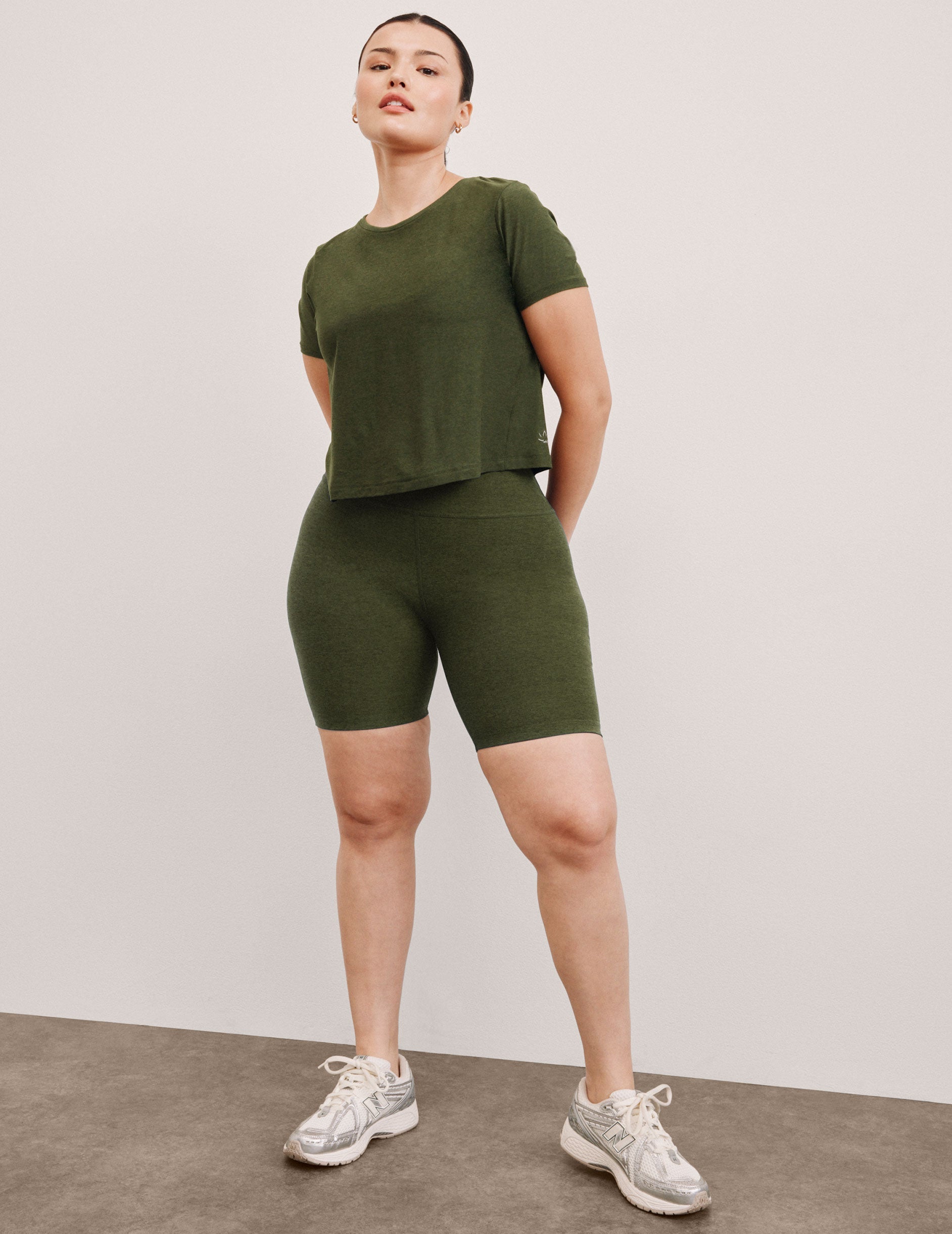 model is wearing green high-waisted 7" inseam biker shorts.