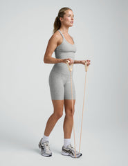 Woman wearing a gray athletic outfit on a white background.