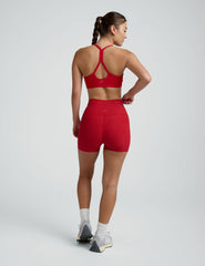 woman wearing red 3" inseam biker shorts against a plain background.