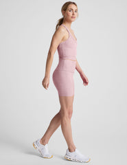 Woman wearing a pink athletic outfit on a white background