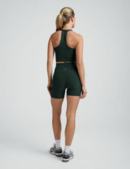 woman wearing a green v-neck cropped tank and green high-waisted 5" biker shorts on a plain backgroun