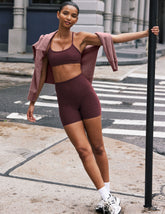 model is wearing red high-waisted 5" inseam biker shorts.