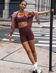 model is wearing red high-waisted 5" inseam biker shorts.