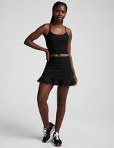 black high-waisted skirt with a ruffle hem and built-in shorts with pockets.