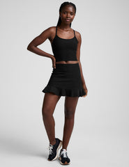 black high-waisted skirt with a ruffle hem and built-in shorts with pockets.