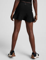 black high-waisted skirt with a ruffle hem and built-in shorts with pockets.