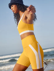 yellow high-waisted spacedye biker shorts with white lining down the sides.