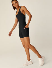 black biker jumpsuit with a crossover strap detail in the back and pockets.