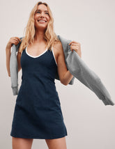 navy blue mini length dress with a front V neckline, back keyhole detail, contrast binding at neckline and arm openings, and an Interior bodysuit with pockets.