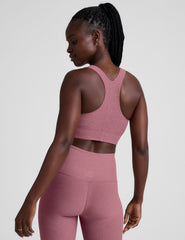 model is wearing a pink scoop neck racerback long line bra.