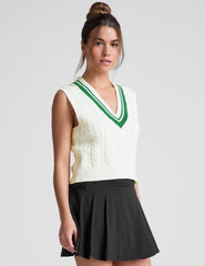 white relaxed fit cable knit vest with a neckline with contrast color stripe, rib hemband, neckline and armholes.
