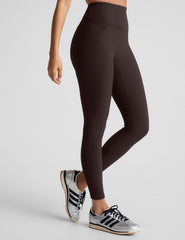 model wearing brown ribbed high-waisted midi length leggings against a plain background.