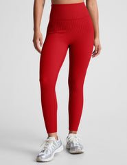 model wearing a red ribbed bra and red high-waisted ribbed leggings against a plain background.