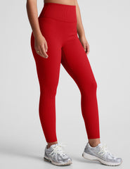 model wearing a red ribbed bra and red high-waisted ribbed leggings against a plain background.