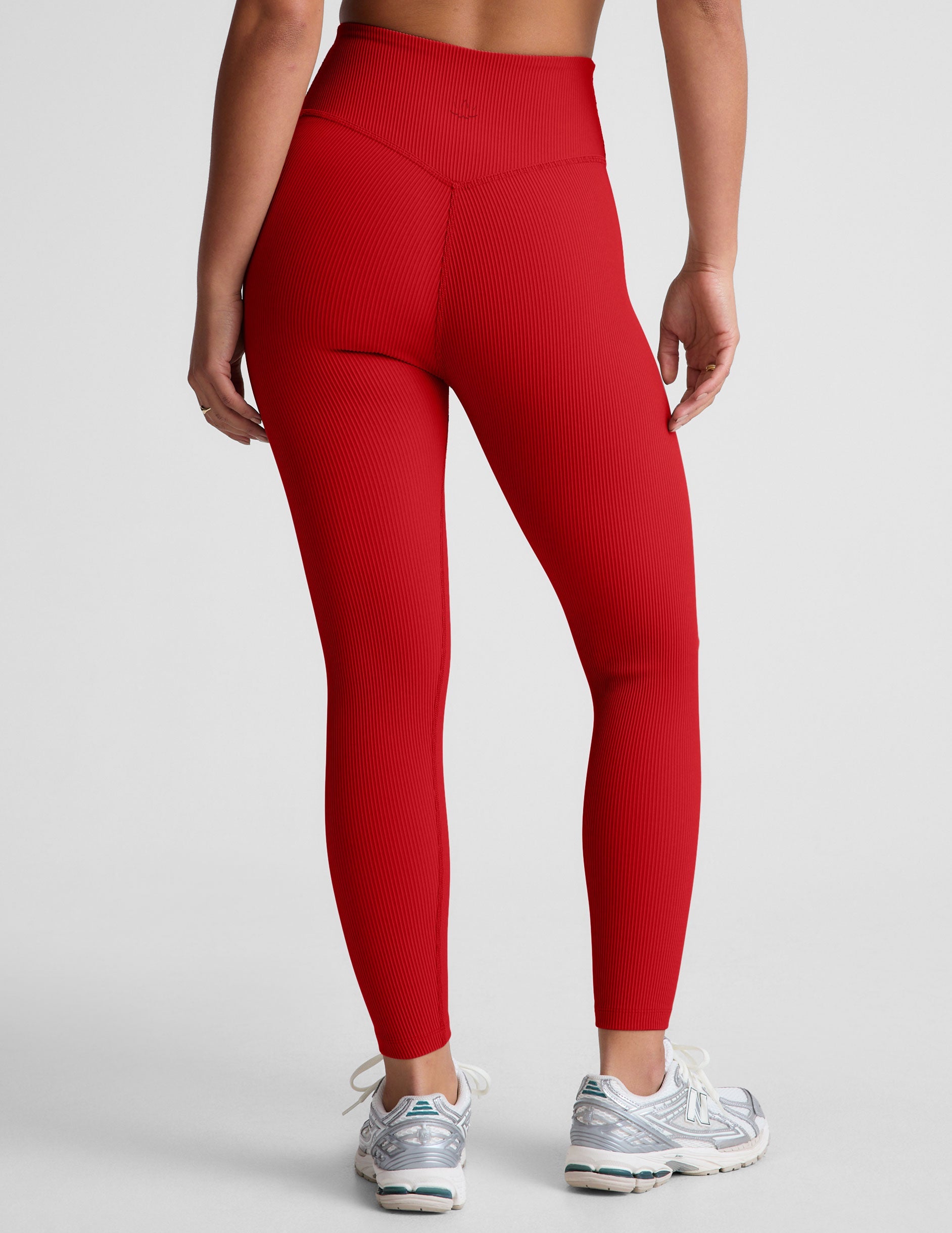 model wearing a red ribbed bra and red high-waisted ribbed leggings against a plain background.