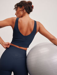 blue ribbed cropped tank top with a soft V neckline front and back​, an overlapping front neckline detail​, and a lining shelf bra​. 