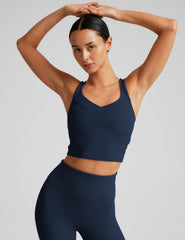 blue ribbed cropped tank top with a soft V neckline front and back​, an overlapping front neckline detail​, and a lining shelf bra​. 