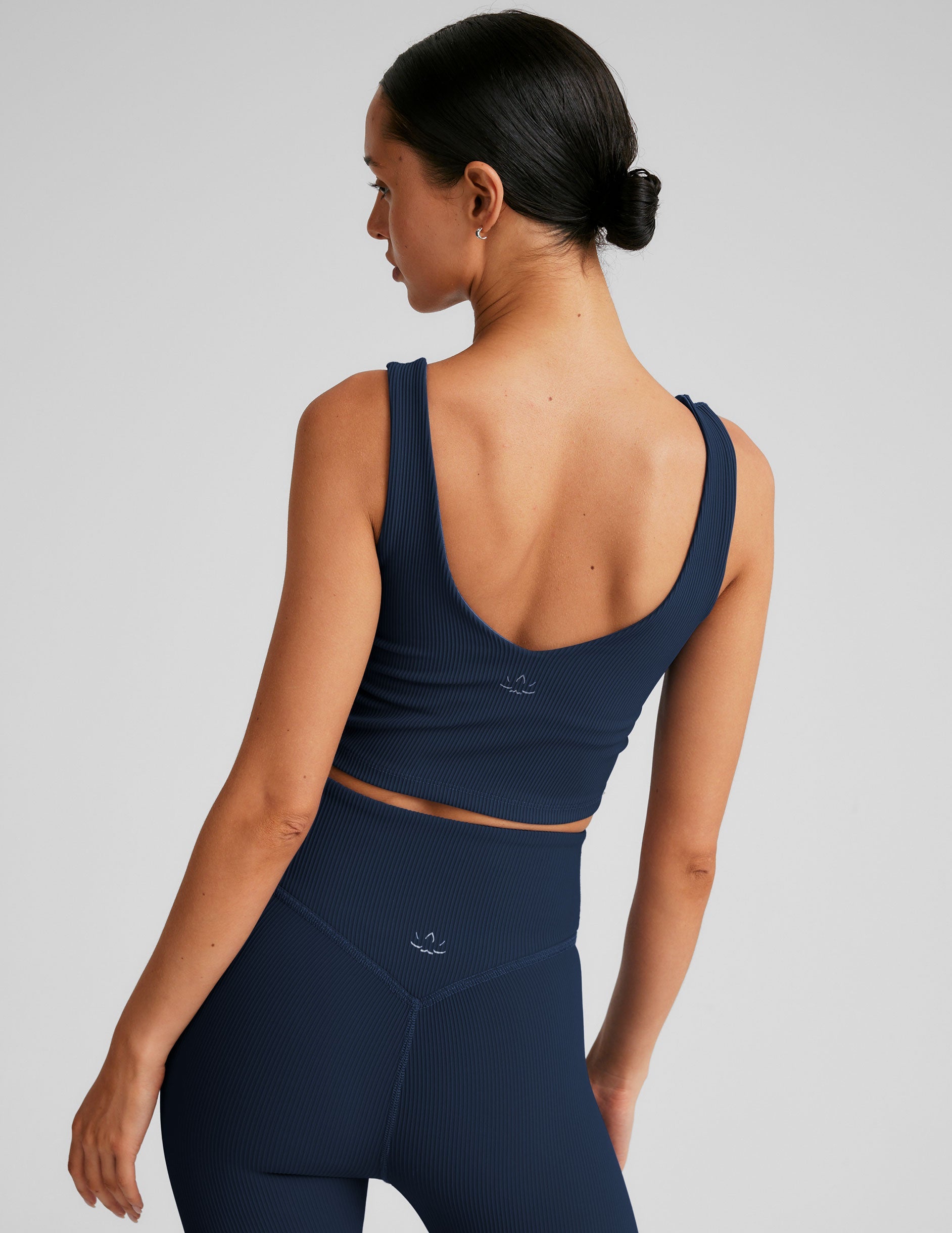blue ribbed cropped tank top with a soft V neckline front and back​, an overlapping front neckline detail​, and a lining shelf bra​. 