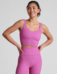 pink ribbed cropped tank top with a soft V neckline front and back​, an overlapping front neckline detail​, and a lining shelf bra​. 