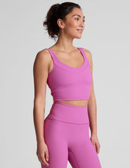 pink ribbed cropped tank top with a soft V neckline front and back​, an overlapping front neckline detail​, and a lining shelf bra​. 