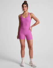pink racerback 5" inseam tank jumpsuit with a front V neckline with overlapping detail. 
