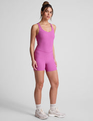 pink racerback 5" inseam tank jumpsuit with a front V neckline with overlapping detail. 