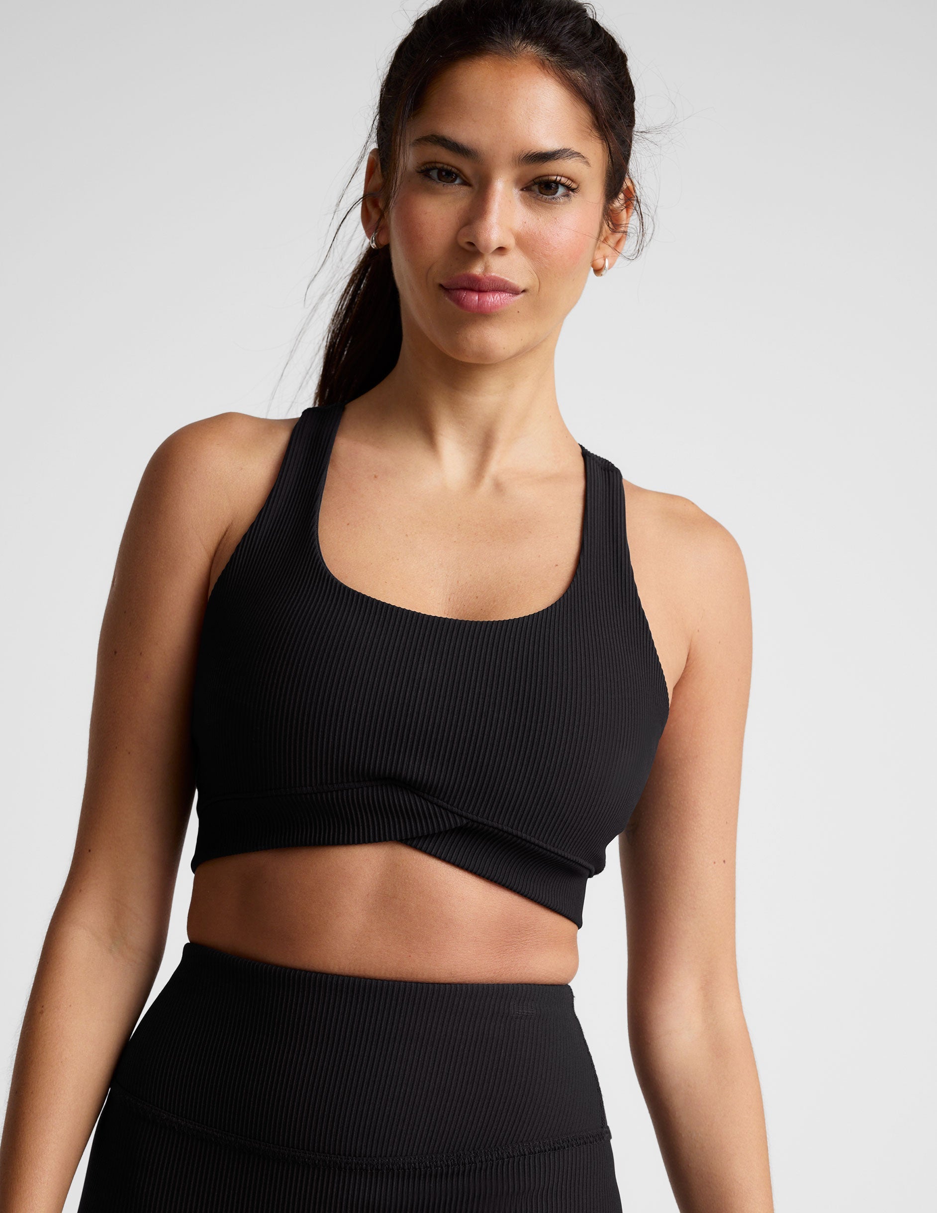 black ribbed racerback bra with overlapping hemband detail​ and a scoop neckline.