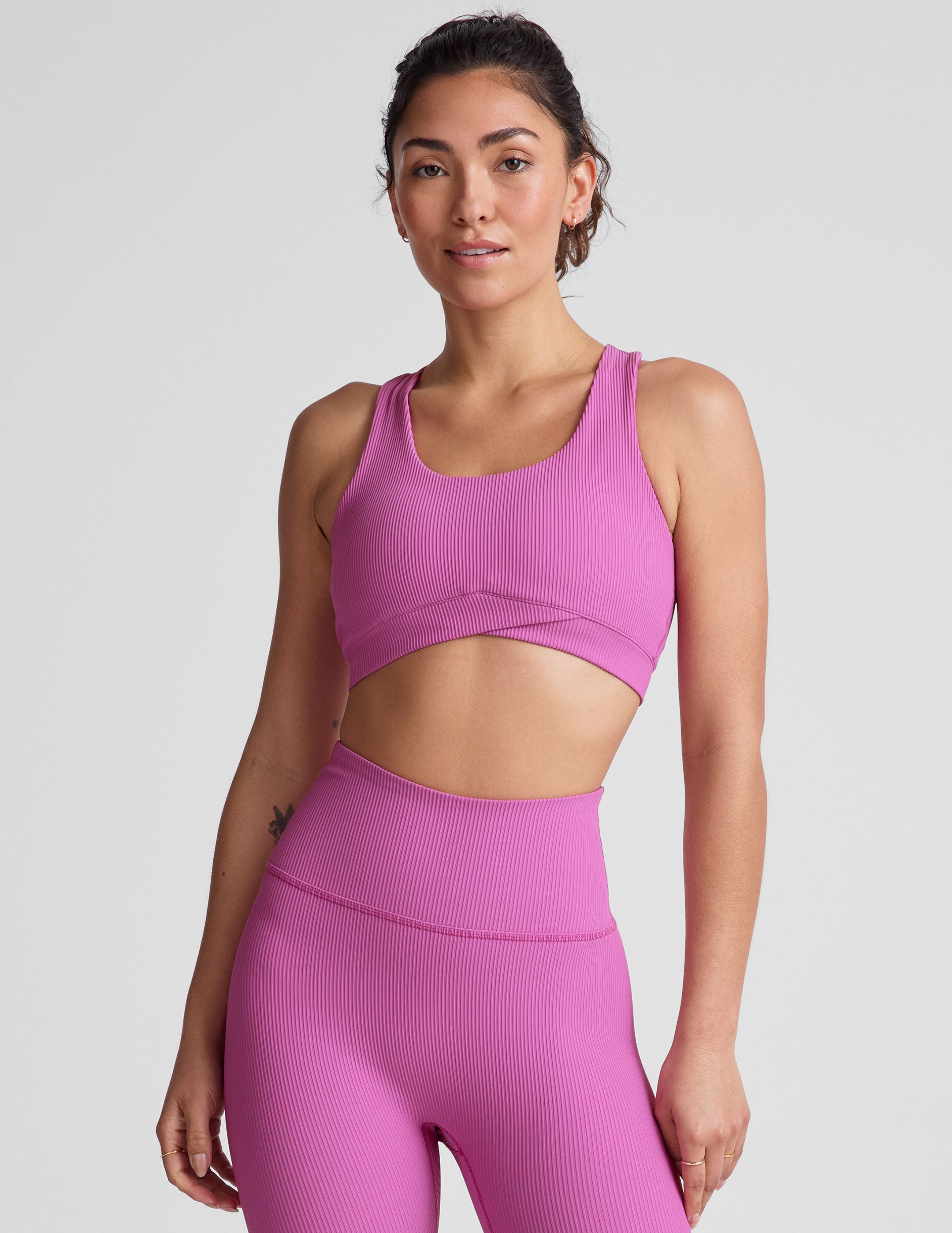 pink medium support racerback bra with a scoop neckline​, overlapping hemband detail​, is lined with performance lining and powermesh in between​, and has removable bra pads​. 